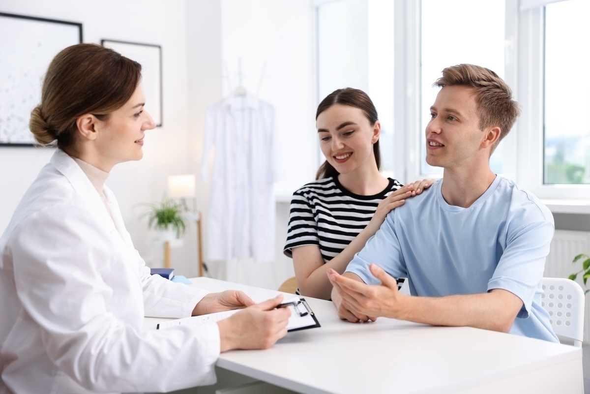 Couple consulting with a healthcare provider about does TRT affect fertility during a medical appointment
