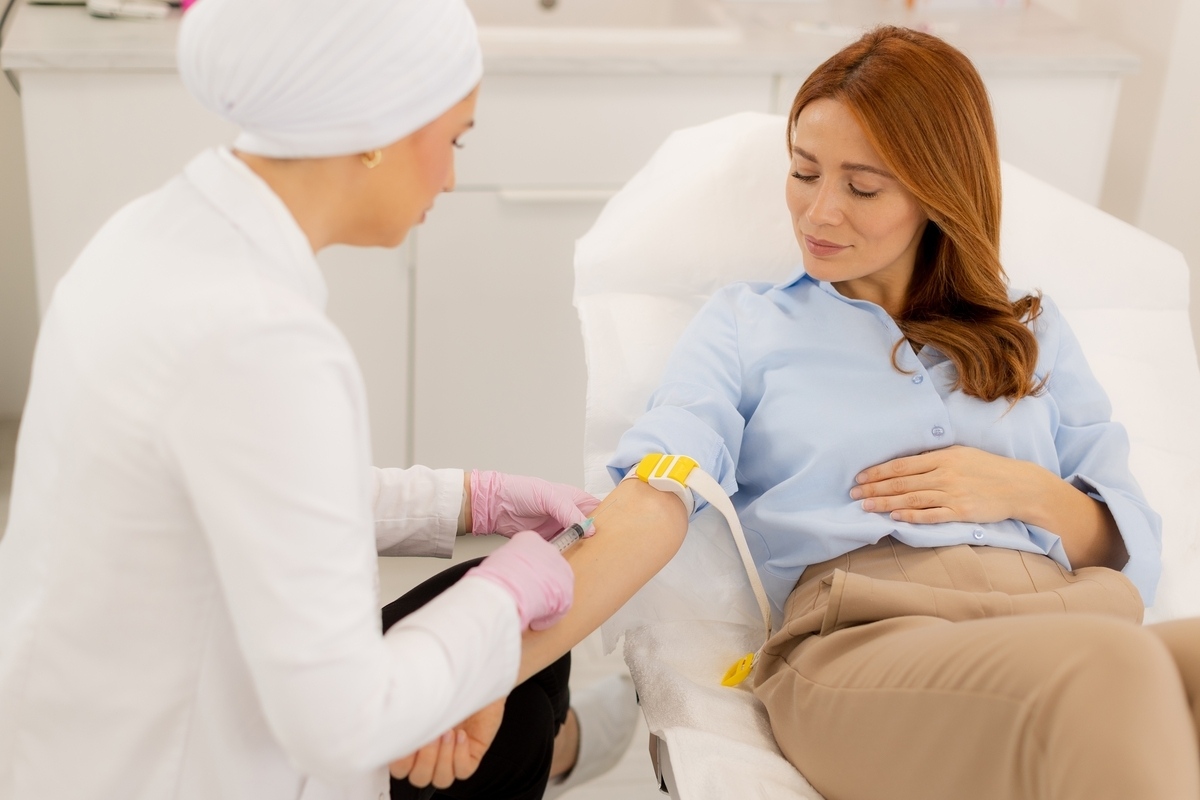 Woman getting blood drawn for lab tests for HRT in a modern clinical setting