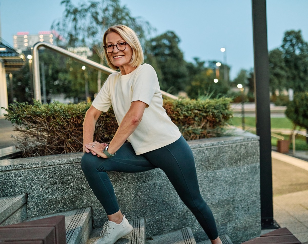 Active woman over 40 stretching outdoors representing the benefits of HRT and bone health in women